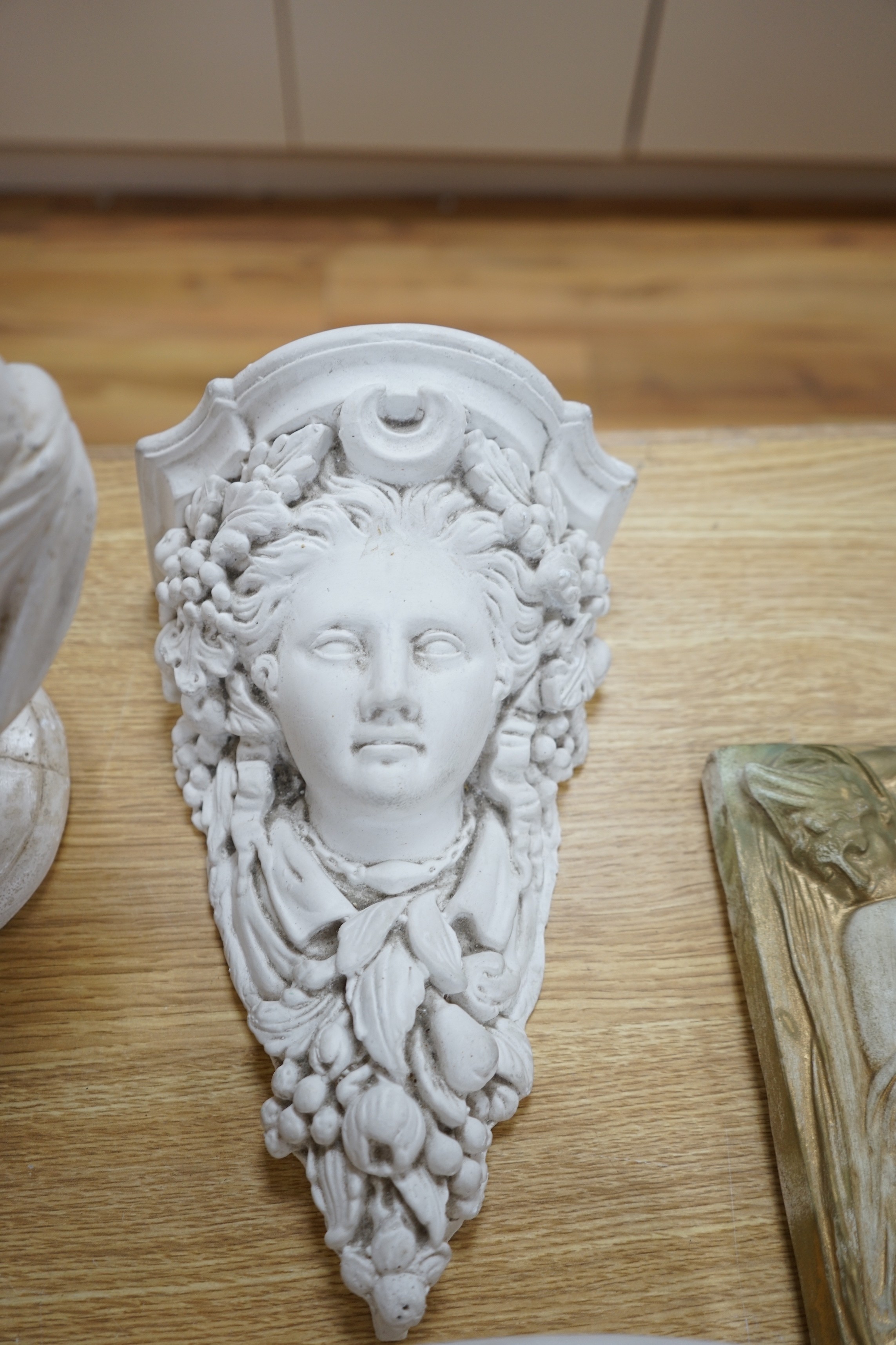 A pair of plaster wall sconces and wall panels, and two busts, tallest 38cms high